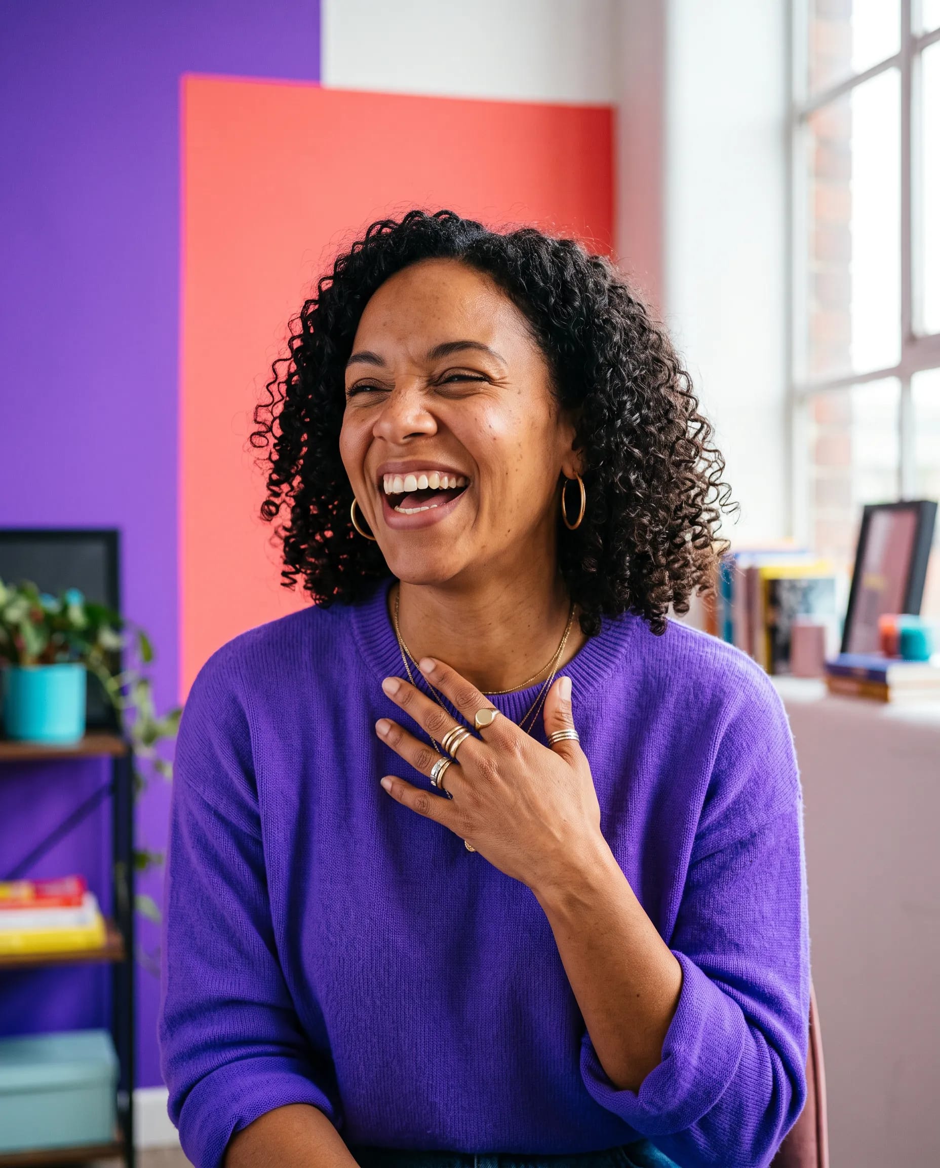 Jade Thompson, ADHD coach, laughing in front of the colour-blocked wall of her Loud Brain Coaching studio in Leeds